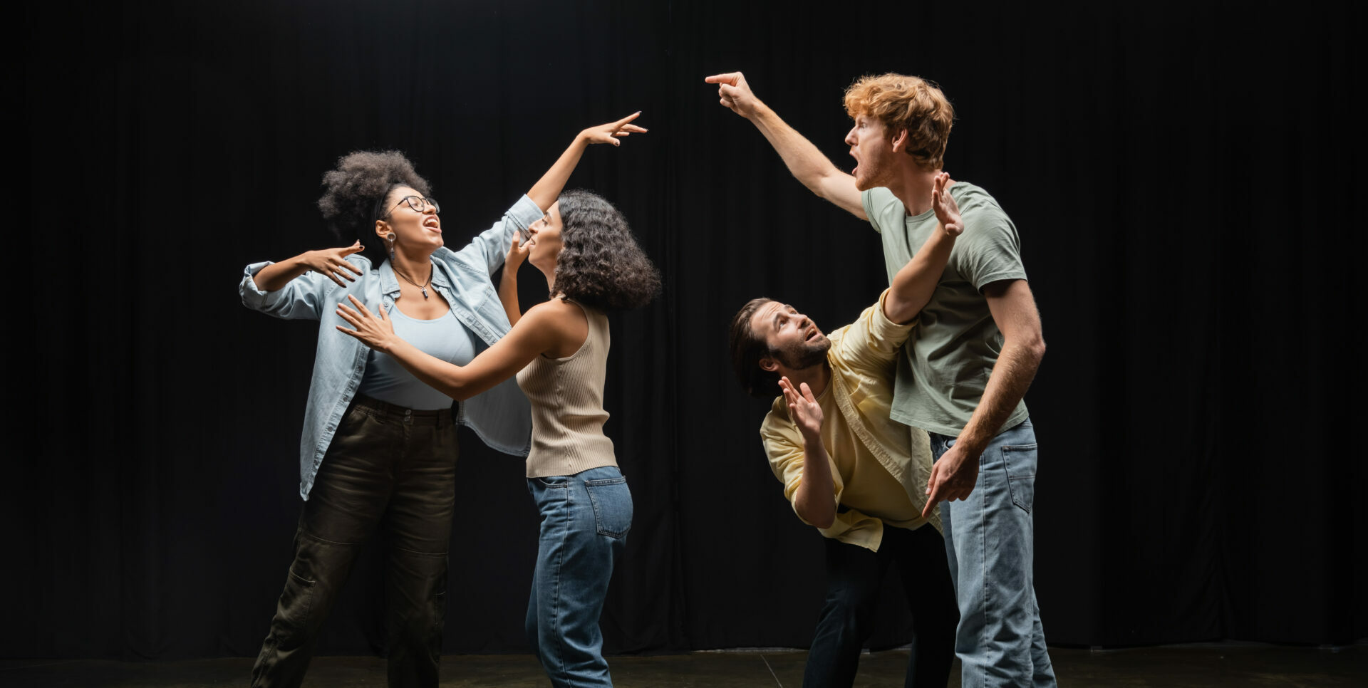 full length of young multiethnic actors posing while rehearsing in acting skills school,stock image