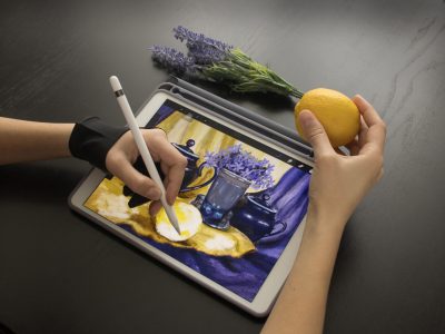 A girl in a special glove draws a still life picture with a penc