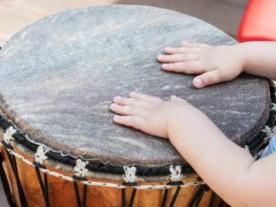 closeup of baby hands on african drums in outdoor